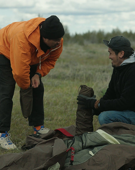 Two individuals work together to set up a Snow Peak tent.